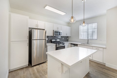 Experience the epitome of modern elegance at The Michael B apartments, where sleek white cabinetry meets state-of-the-art stainless steel appliances, setting the stage for gourmet culinary adventures.